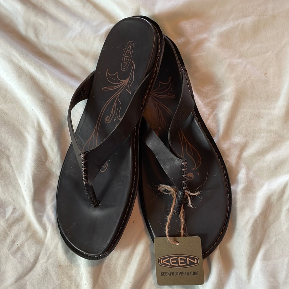New Keen size 9 flip flops in black are in style called “Alman.”